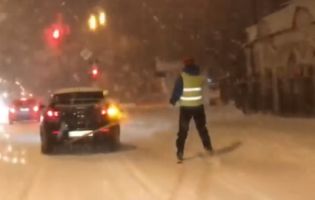 В Ужгороді екстремал учепився за авто і прокатався засніженим містом на лижах (відео)